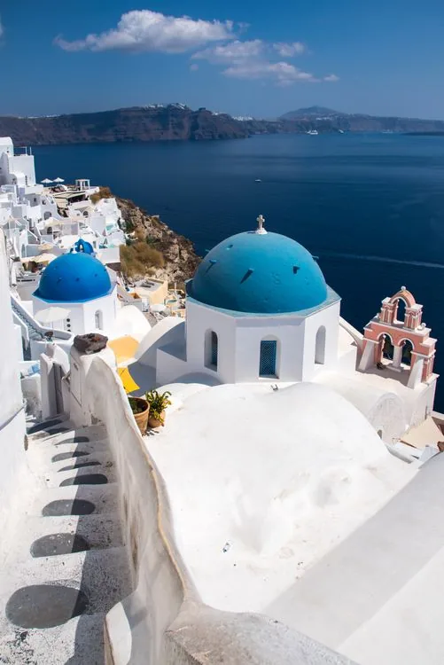 Blue-domed churches and white houses of Oia above the Aegean Sea, Santorini