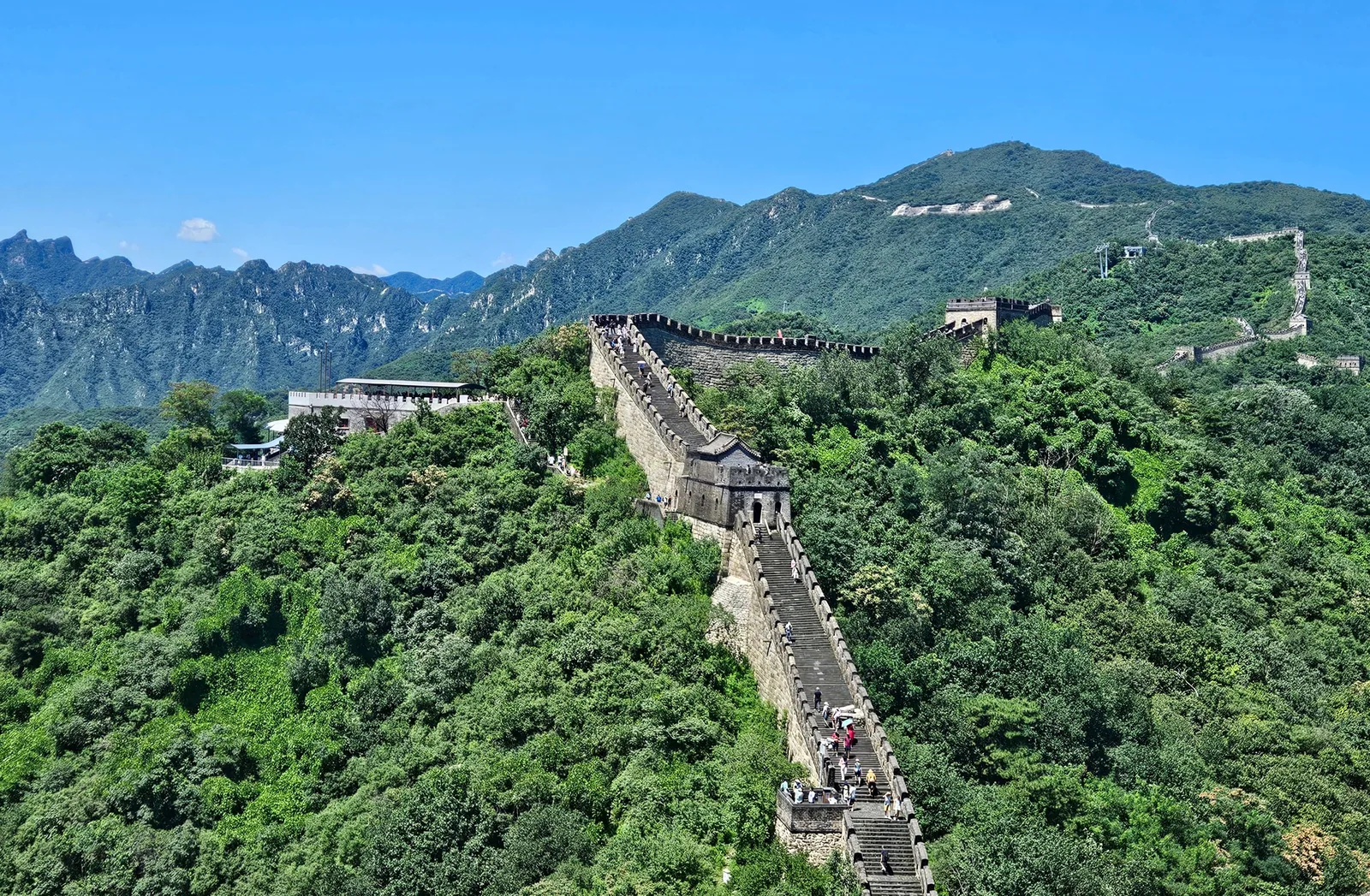 Aerial view of the Great Wall of China winding through green mountains