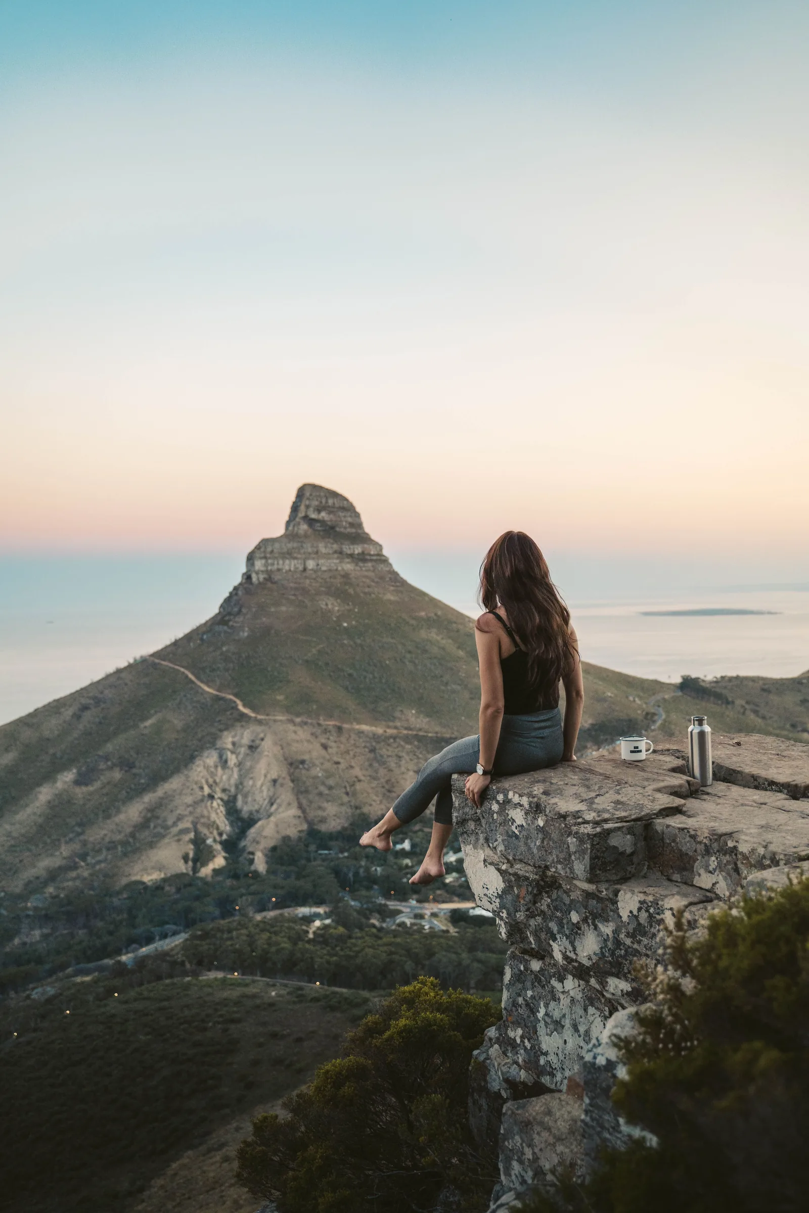 Woman overlooking Lion's Head and the Cape Town coastline at sunset