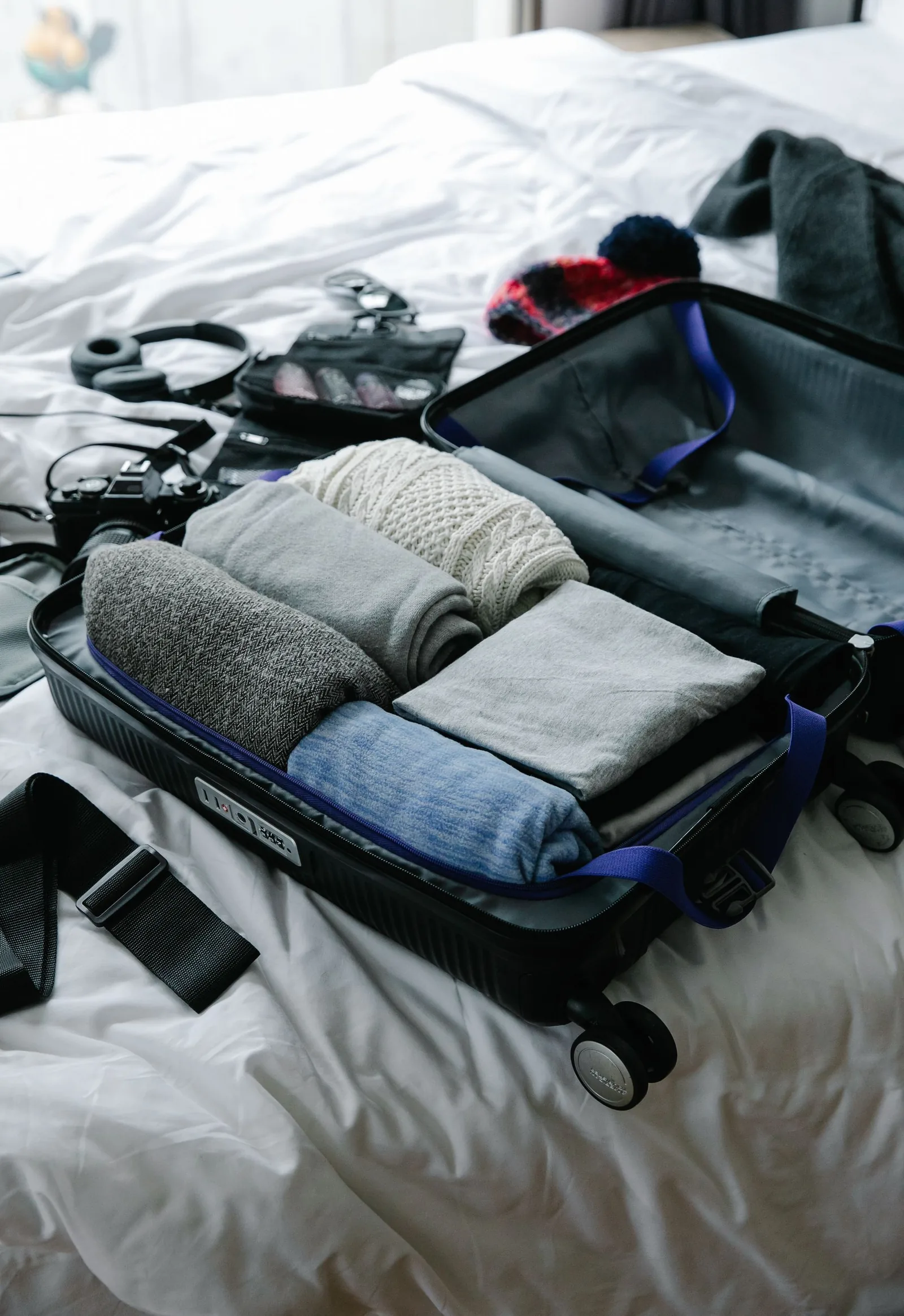 Open carry-on suitcase packed with neatly folded clothes