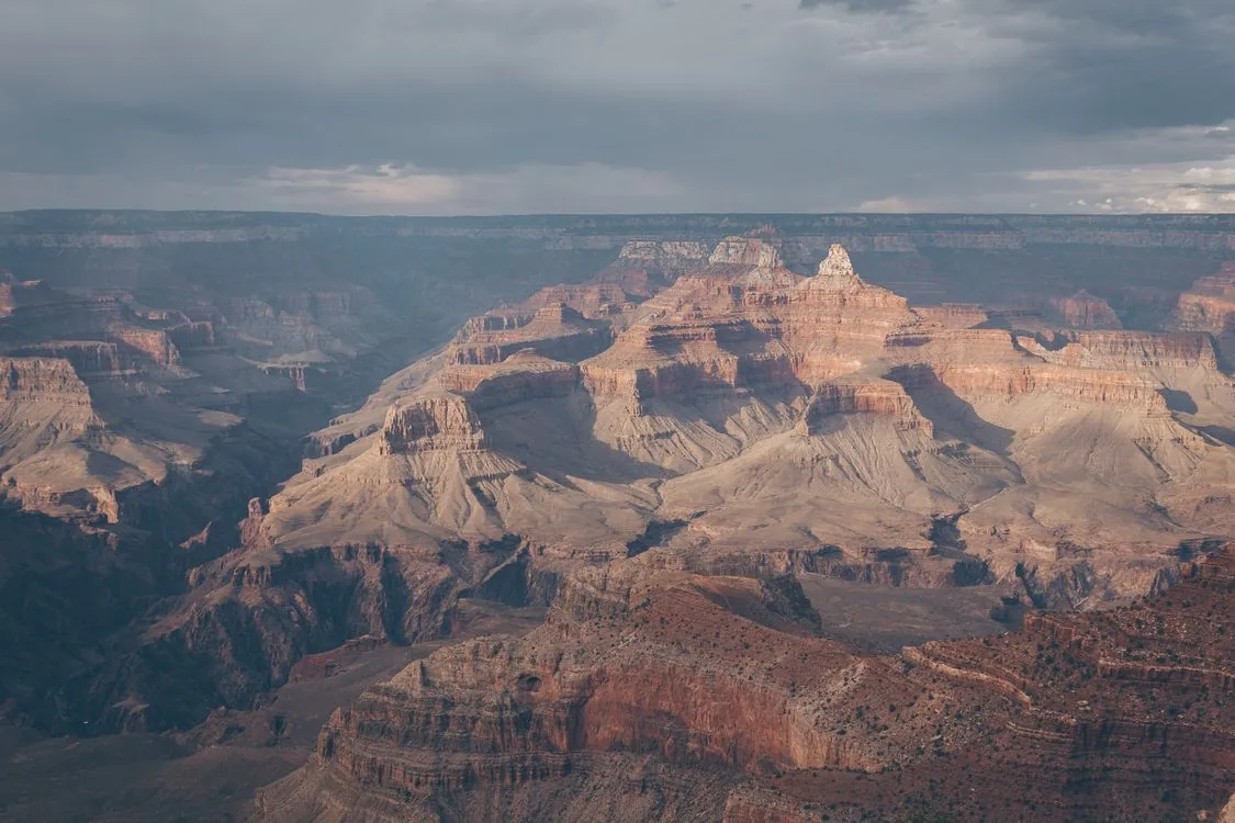 Layered rock ridges of the Grand Canyon under dramatic skies, seen from the South Rim